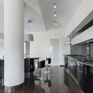 Μοντέρνα κουζίνα με γυαλιστερό μαύρο φινίρισμα και νησίδα με μαύρα ψηλά σκαμπό, ιδανική για σύγχρονα σπίτια.