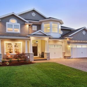 Μοντέρνα διώροφη μονοκατοικία με φωτισμένη είσοδο και φροντισμένο κήπο, ιδανική για πολυτελή διαβίωση.