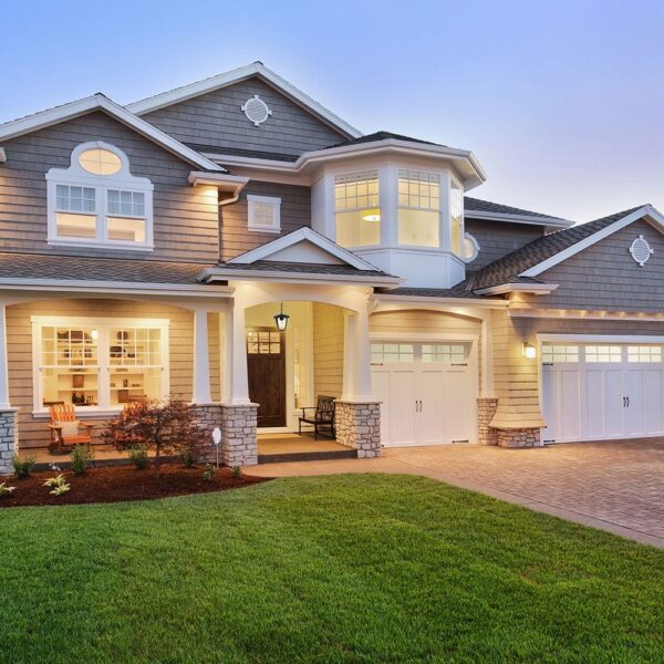 Μοντέρνα διώροφη μονοκατοικία με φωτισμένη είσοδο και φροντισμένο κήπο, ιδανική για πολυτελή διαβίωση.