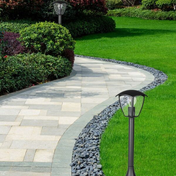 Πλακόστρωτο μονοπάτι με φωτισμό κήπου, περιτριγυρισμένο από πράσινο γρασίδι και θάμνους.