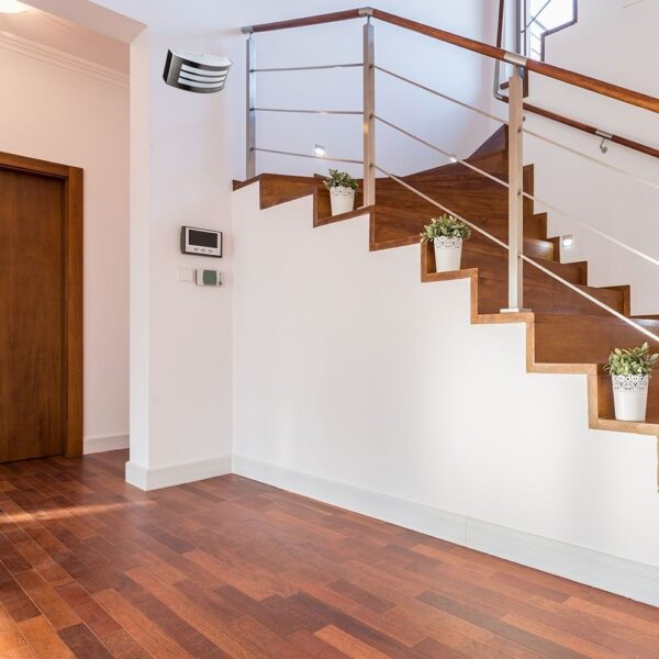 Ξύλινη σκάλα εσωτερικού χώρου με μεταλλικό κιγκλίδωμα και διακοσμητικές γλάστρες, ιδανική για μοντέρνα διακόσμηση.